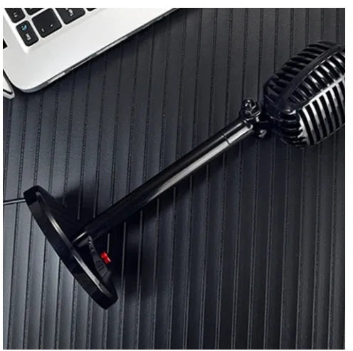 Black USB computer microphone with adjustable stand on desk for recording