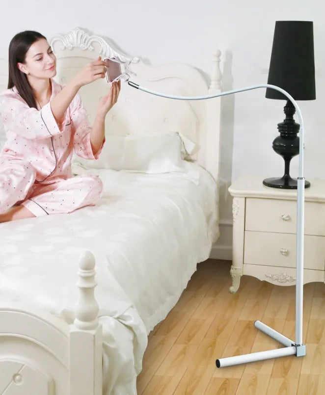 Black mobile phone bracket mounted on bed frame holding smartphone for comfortable viewing