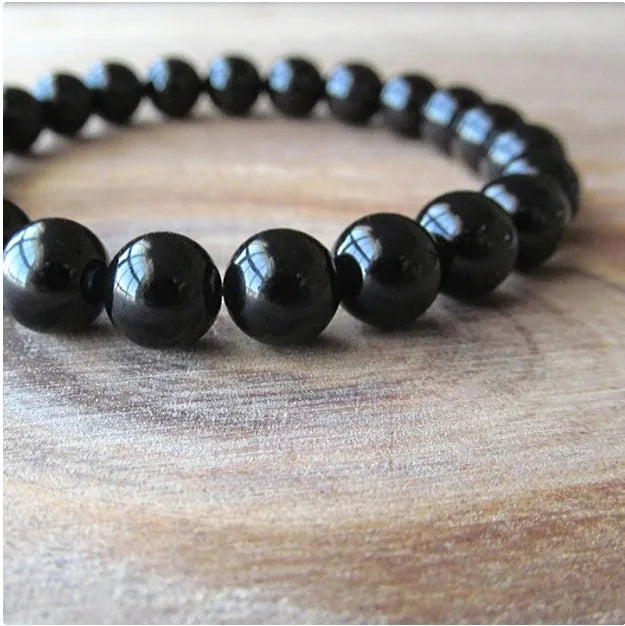 Women's black onyx agate beaded bracelet with geometric design and elastic cord.