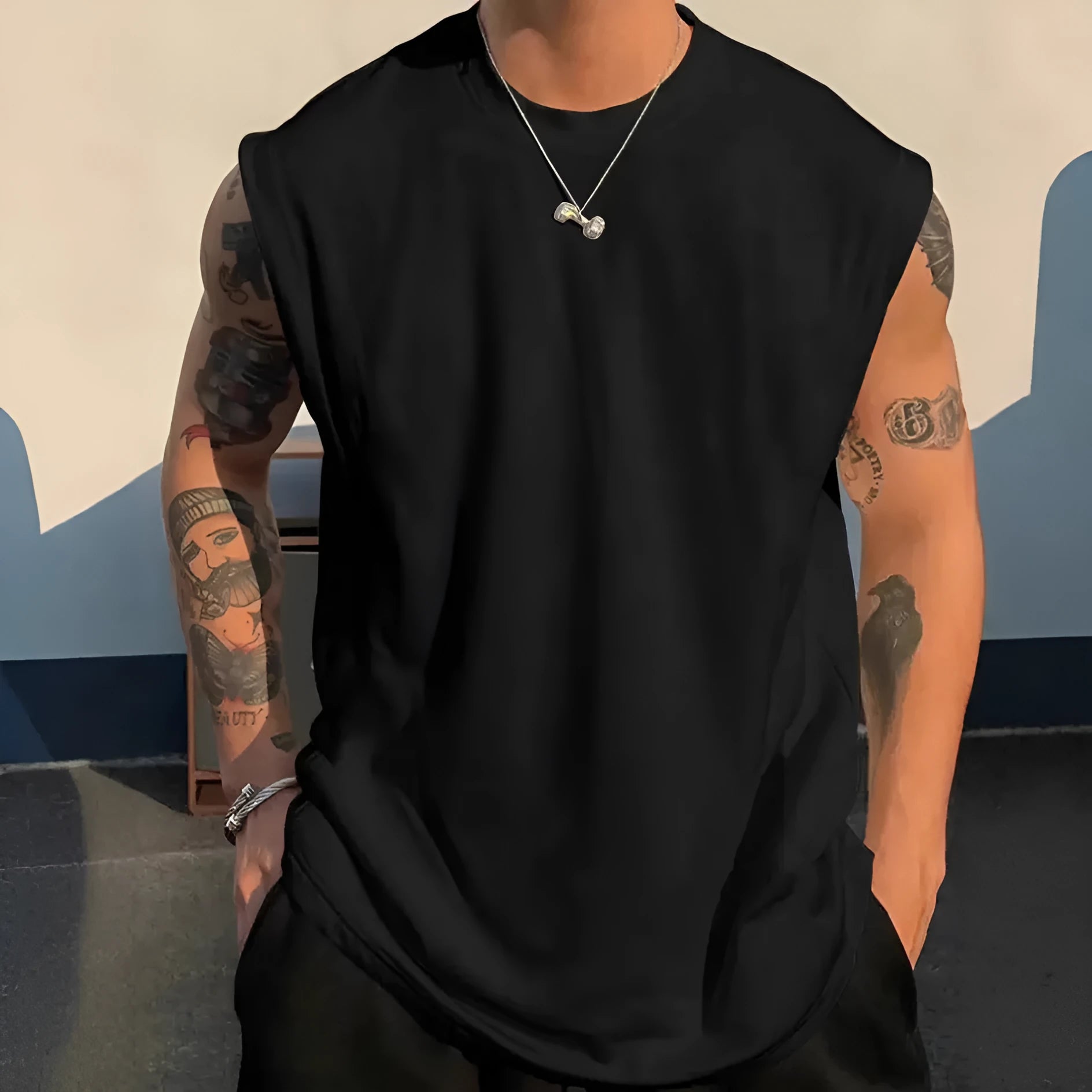 A man's loose grey cotton sleeveless t-shirt on a hanger, showing the straight hem and pullover design.