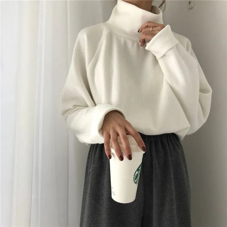 Women's loose-fit long sleeve top with a half-high collar in solid apricot colour, laid flat.