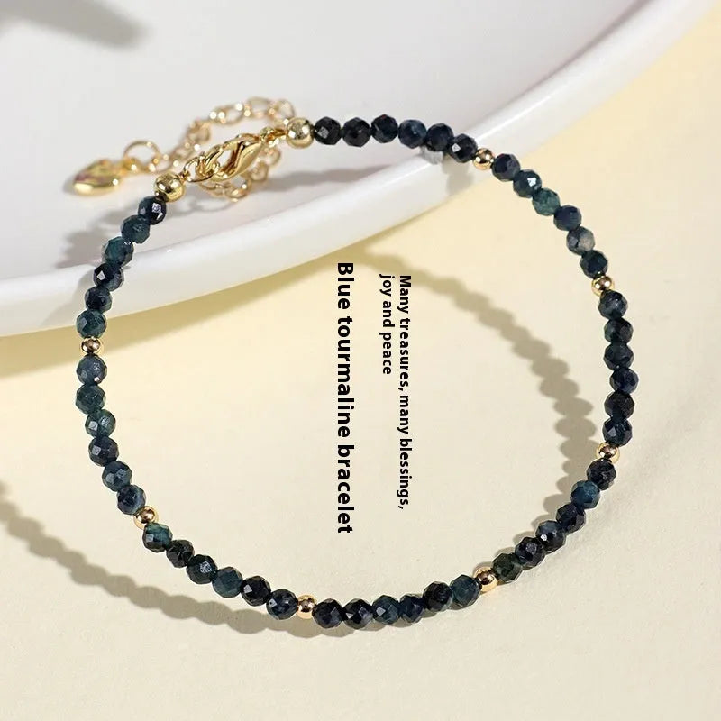 Close-up of a blue tourmaline bracelet with 3mm cut beads and spacer beads.