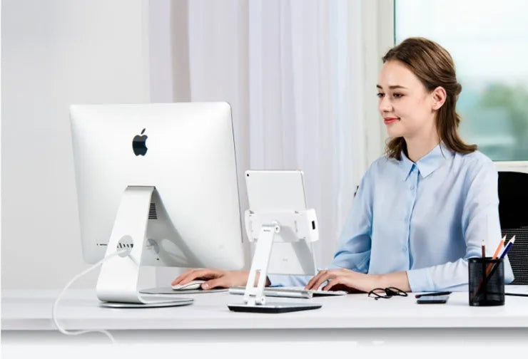 Silver folding aluminium phone and tablet stand with 360° rotation on wooden desk