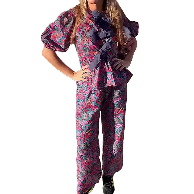 Women's floral print trouser suit with tie-neck blouse featuring puff sleeves