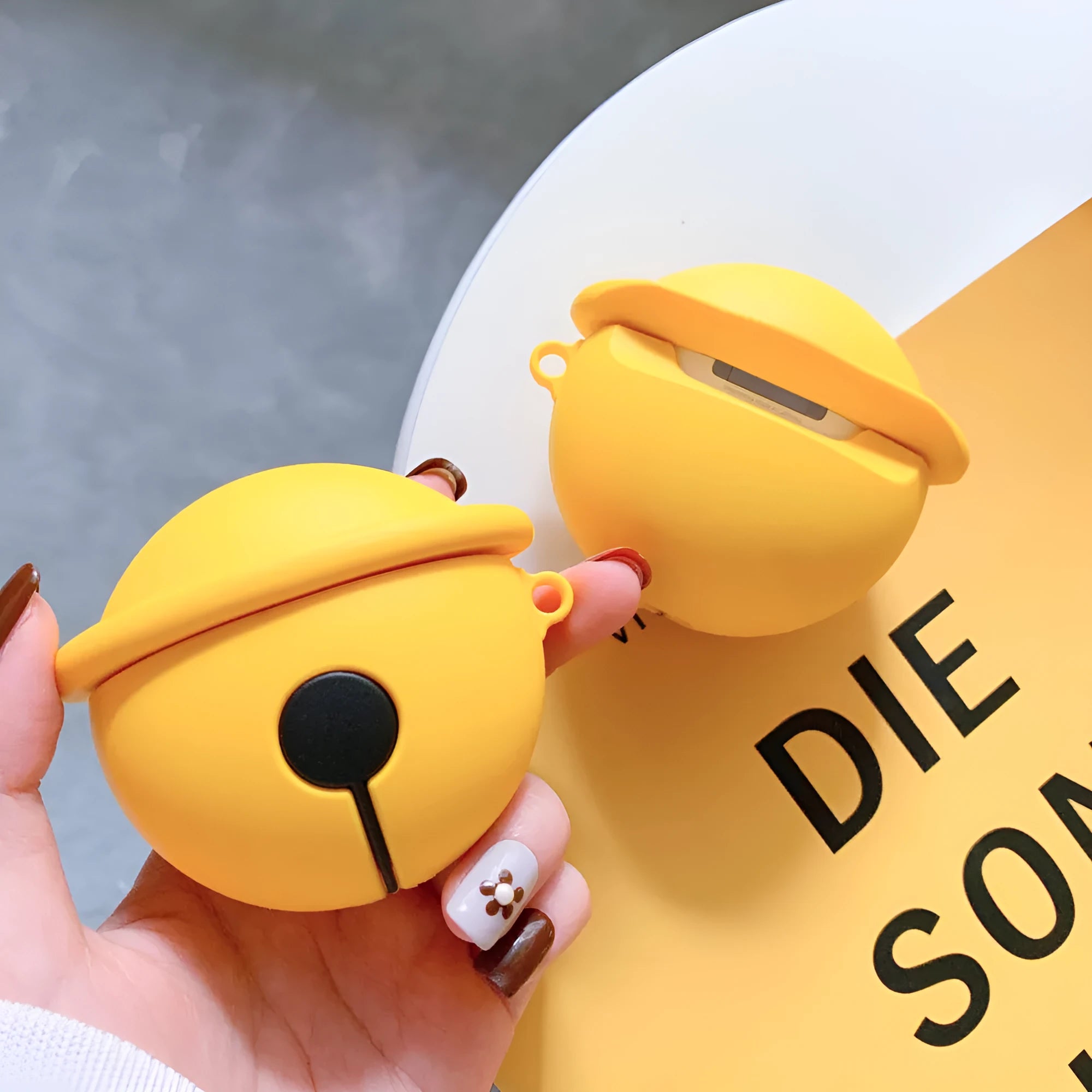 Yellow silicone bell-shaped protective case for AirPods and universal headphones.