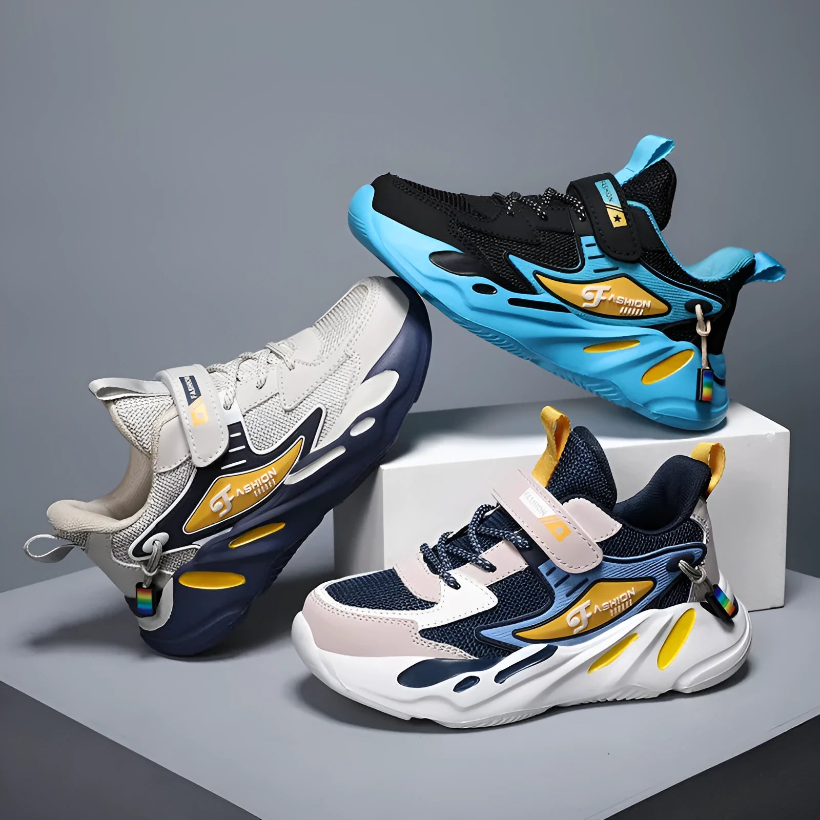 Boys' blue and black Velcro fastening sports running shoes on a white background.
