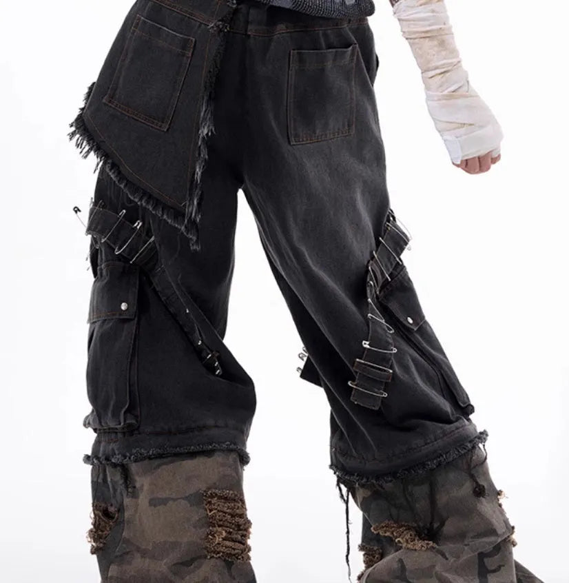 Men's grey cotton jeans with camouflage pattern splicing and decorative pin and ribbon details on the legs.