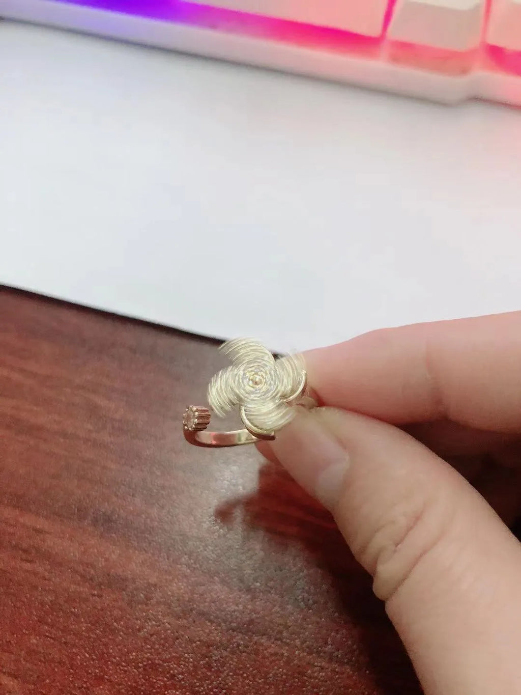 Copper ring with a rotating silver windmill design in the centre.