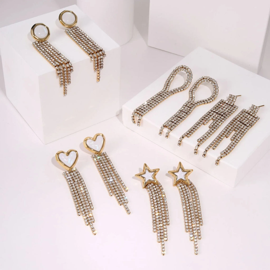 A pair of gold electroplated stainless steel earrings featuring geometric heart and five-pointed star shapes in a dangle style.