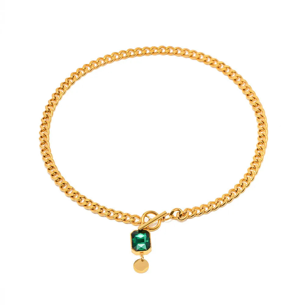 Gold titanium steel necklace with round emerald green zircon pendant on a Cuban link chain.