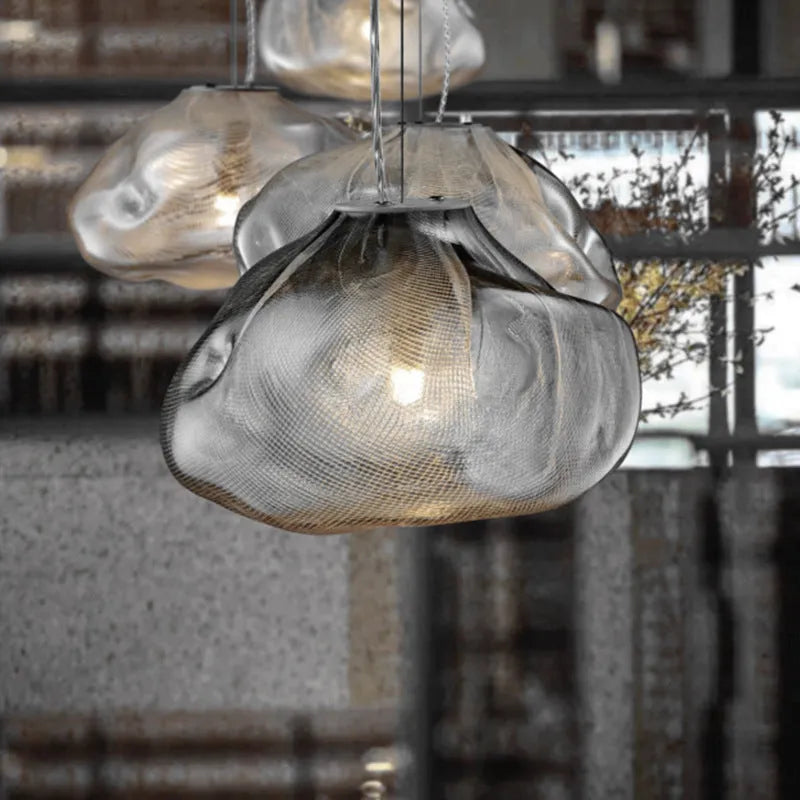 Modern decorative chandelier with glass shade and fabric design, available in amber, clear, or smoke grey.