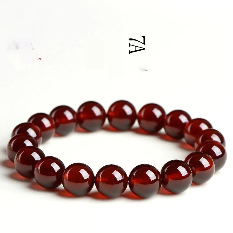 Natural orange red garnet ball bracelet with Ruyi elements on a wrist, showing retro unisex design.