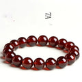 Natural orange red garnet ball bracelet with Ruyi elements on a wrist, showing retro unisex design.