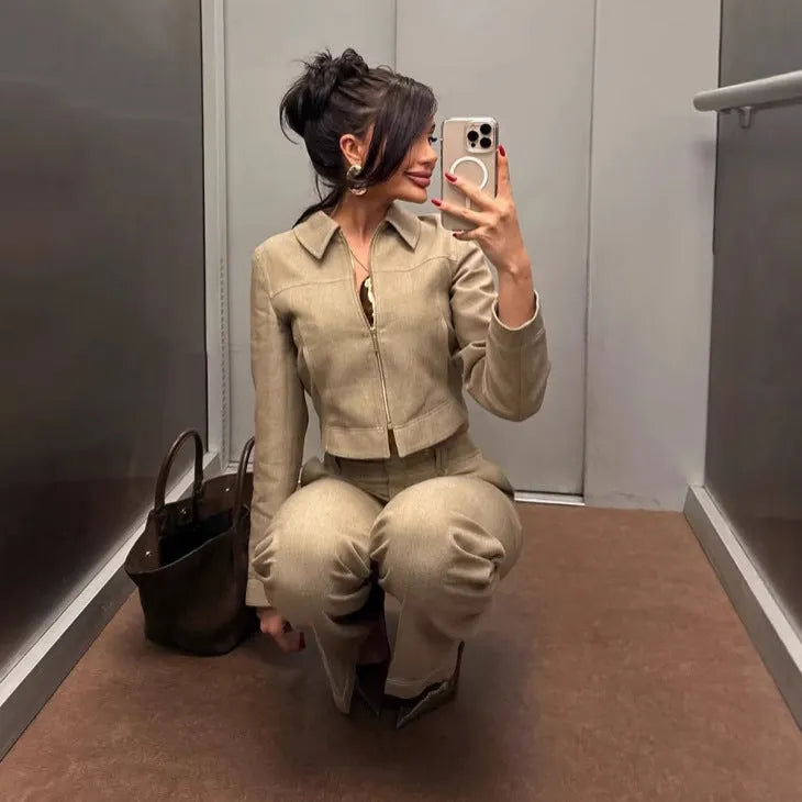 Women's grey herringbone pattern suit with long sleeve coat and straight-leg trousers, showing embroidery detail.