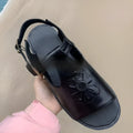 Men's black embroidered floral beach sandals with flat heel on a plain background.