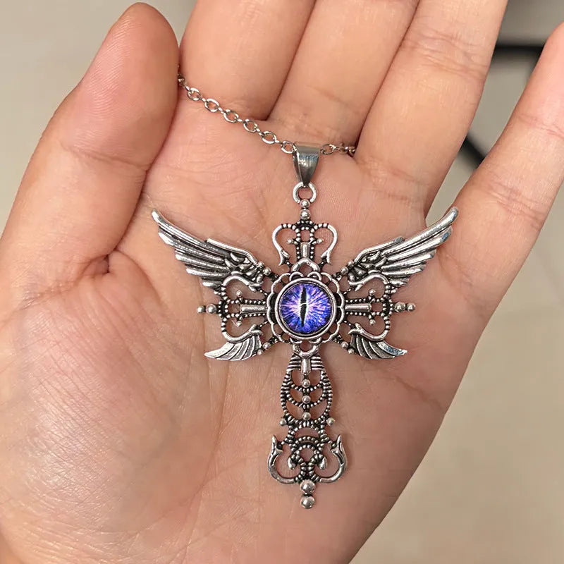 Close-up of a blue alloy necklace featuring a geometric cross pendant with detailed devil wings.