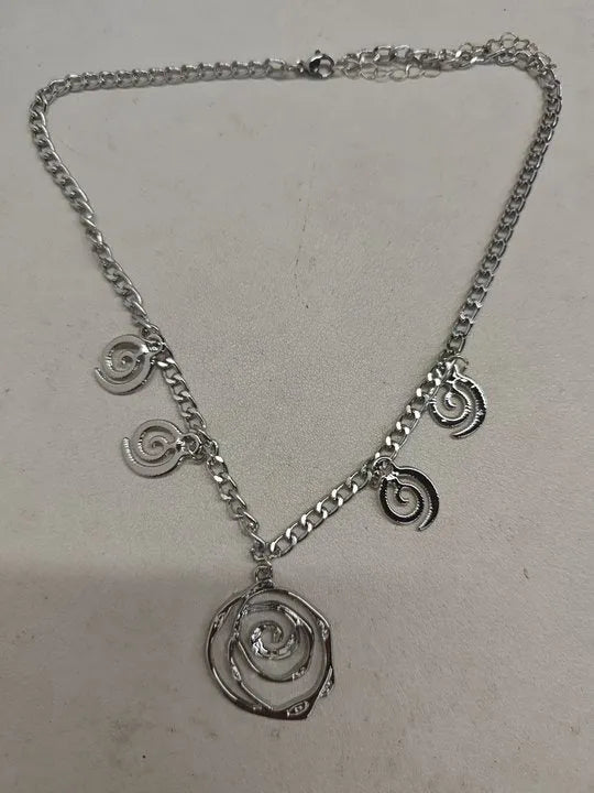 Gold and silver spiral donut pendant necklace, bracelet, and earrings set for women.