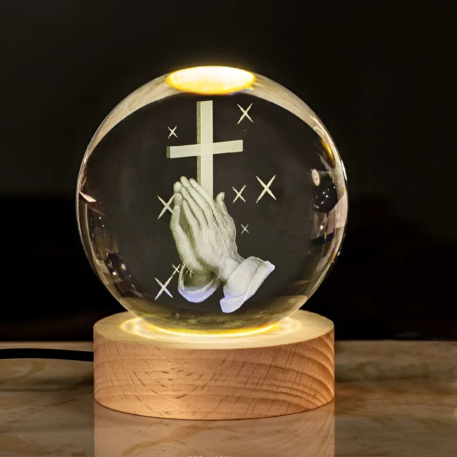 White crystal ball desk ornament with religious symbols on warm light wooden base