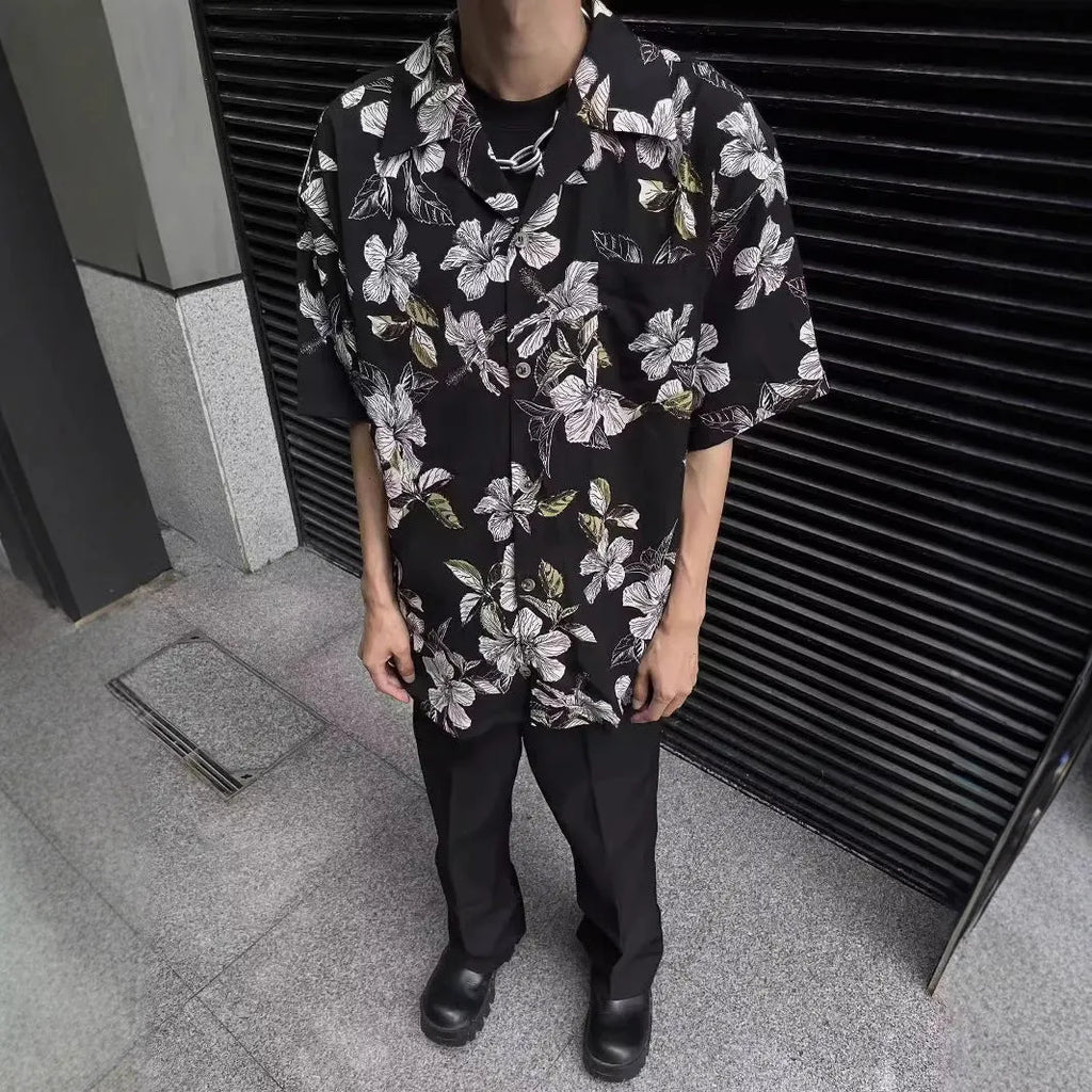 Men's black floral print ice silk Cuban collar short sleeve shirt laid flat.
