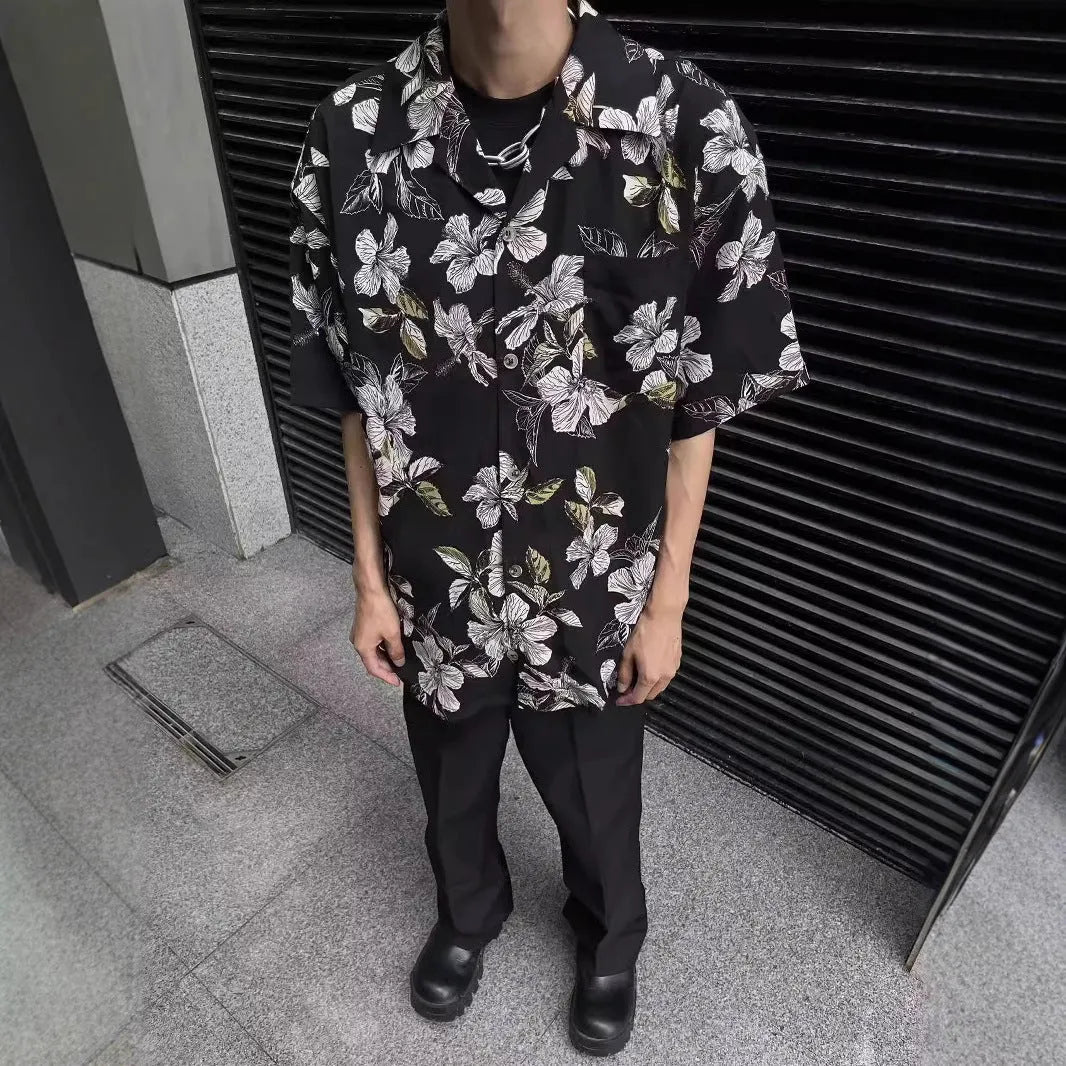 Men's black floral print ice silk Cuban collar short sleeve shirt laid flat.