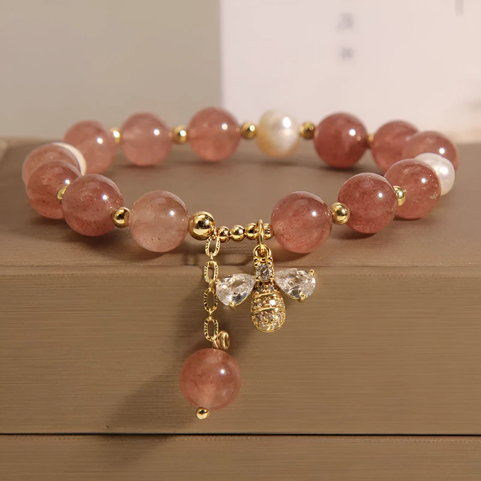 Pink strawberry quartz and white freshwater pearl bracelet with bee charm and zircon accents