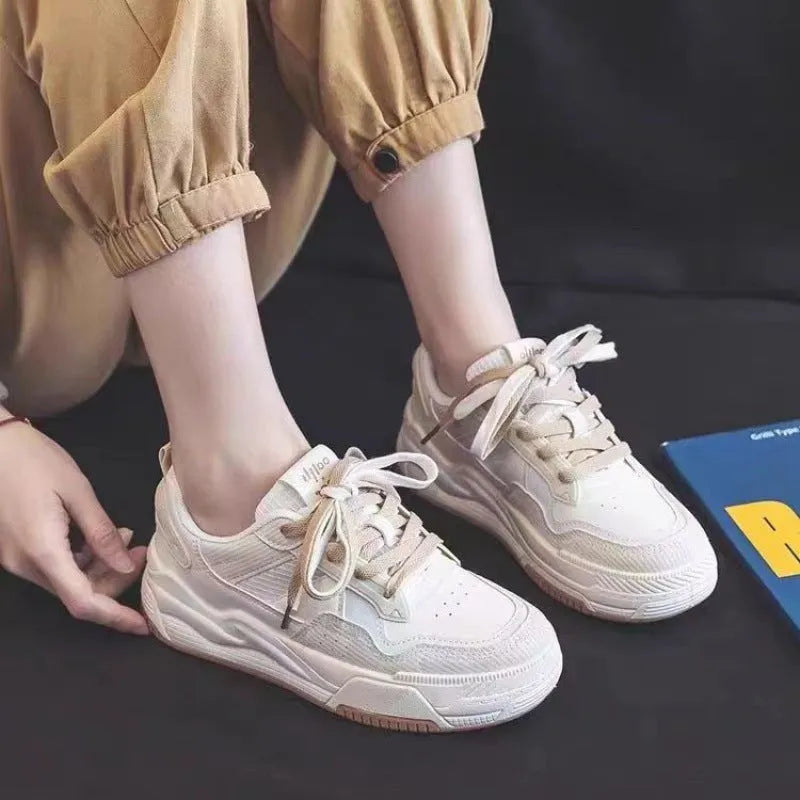 Pink and white low-top sneakers with rubber soles and imitation leather lining