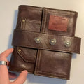 Brown A7 notebook with retro leather buckle closure showing loose-leaf binding