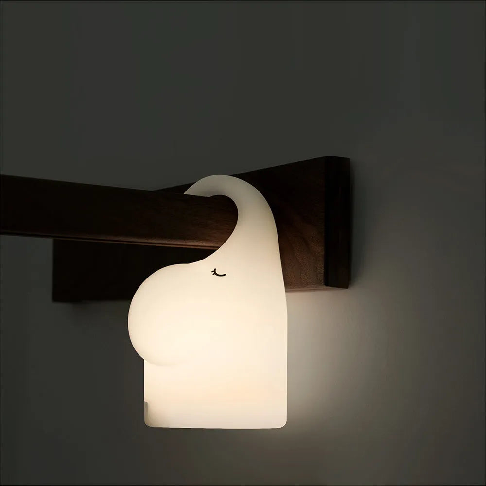 Soft silicone elephant night light with warm white LED glow on bedside table