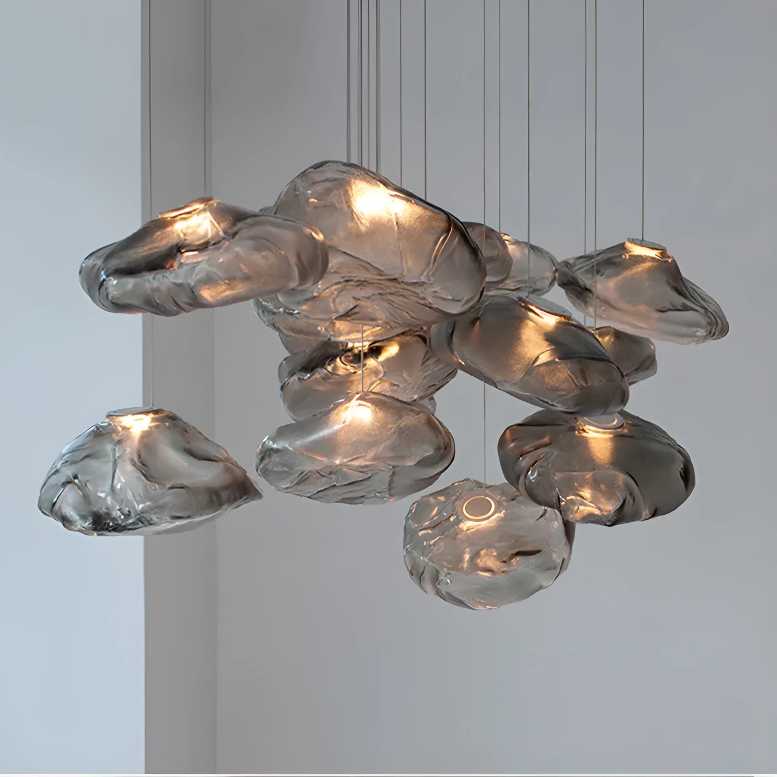 Modern decorative chandelier with glass shade and fabric design, available in amber, clear, or smoke grey.