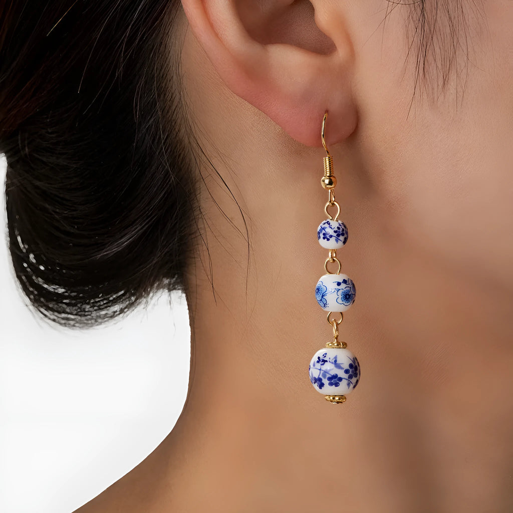 Blue and white porcelain ceramic beads long drop earrings on display with geometric round shape and alloy backing