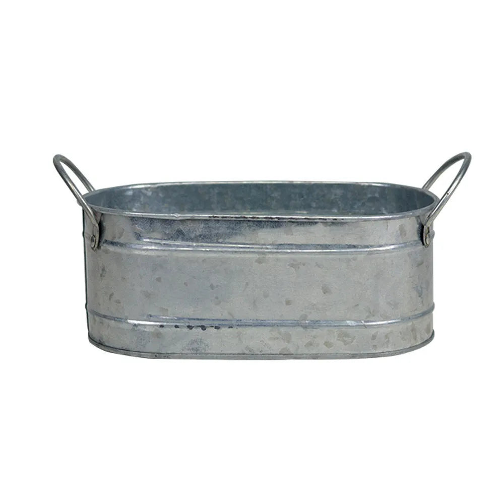 Galvanised iron succulent flowerpot with rustic finish on a wooden desk.