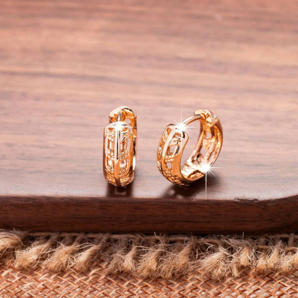 A pair of rose gold hollowed earrings with intricate leaf and heart shapes.