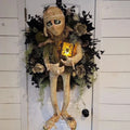 Three-dimensional mummy Halloween wreath with skeleton hands on a wooden door