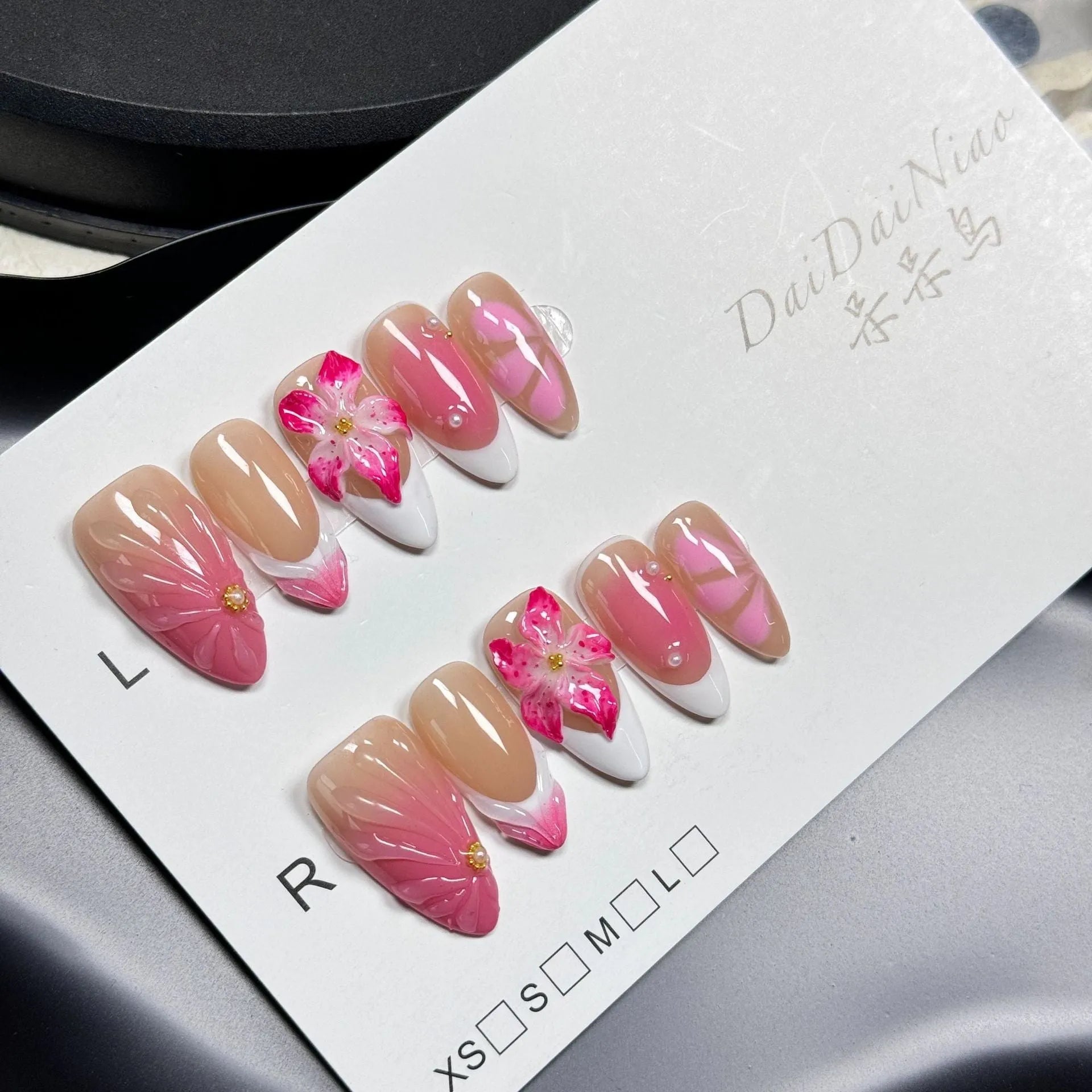 Plastic French style artificial nails with 3D lily and ice flower designs in almond shape, shown in multiple sizes.