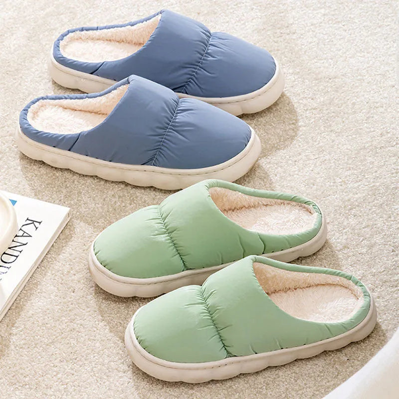 Blue winter house slippers with artificial leather upper, thick rubber sole, and plush lining on a wooden floor.