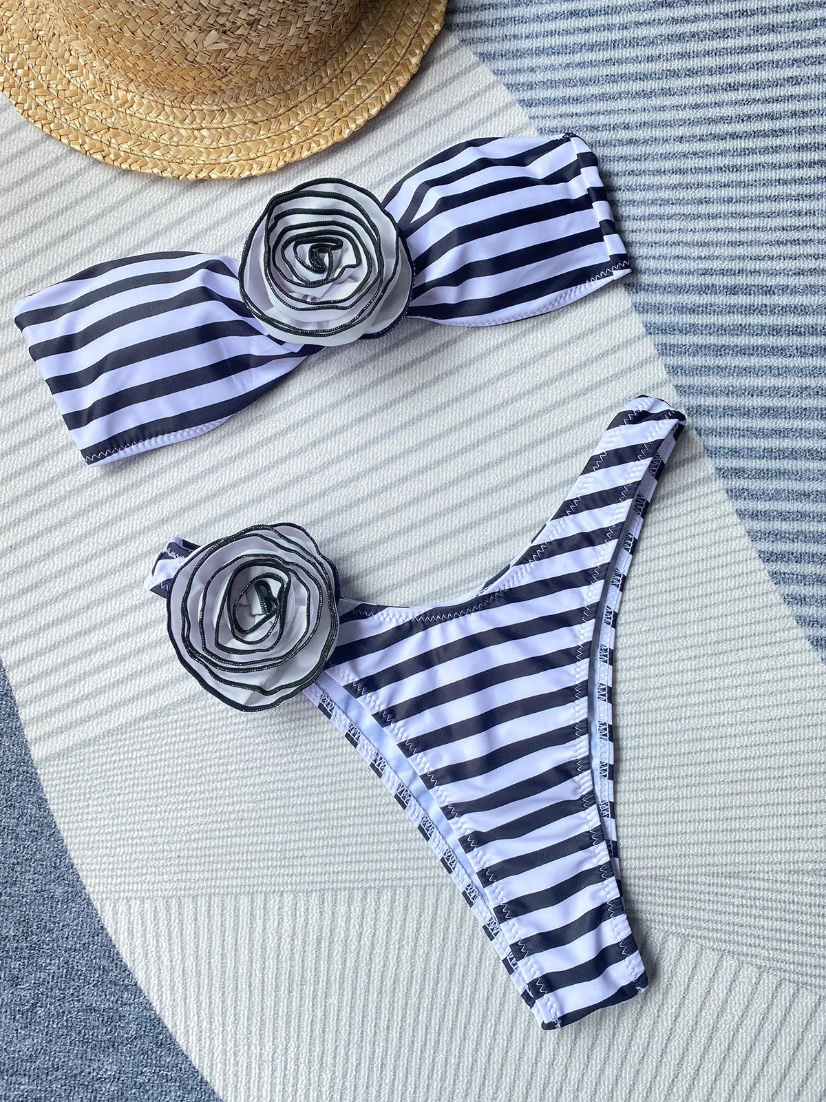 A striped bikini swimsuit with a cross-back tube top featuring a 3D flower and split leg briefs.