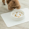 Pet slow food bowl with raised mountain bumps in off-white colour on a floor mat