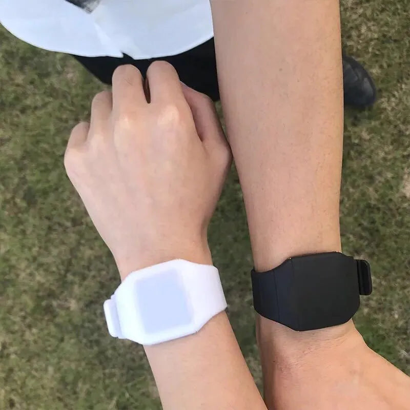 Square plastic electronic watch with digital display on a coloured PU strap, showing touch screen and button controls.