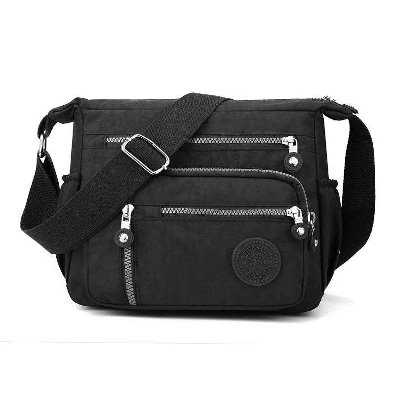 Soft nylon shoulder messenger bag in a square vertical shape with a single strap.
