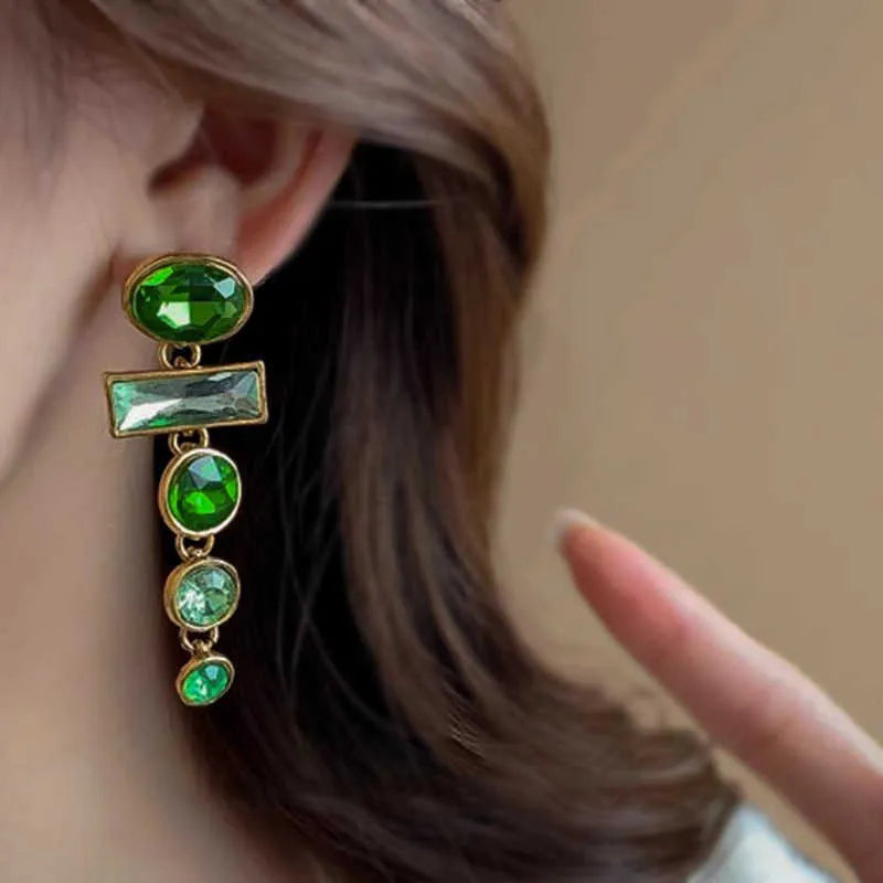 A pair of retro green gradient alloy earrings with geometric shapes and a long tassel design.