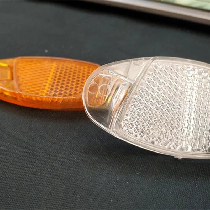 Plastic bicycle spoke reflector strips in white and yellow colours measuring 7.2cm long