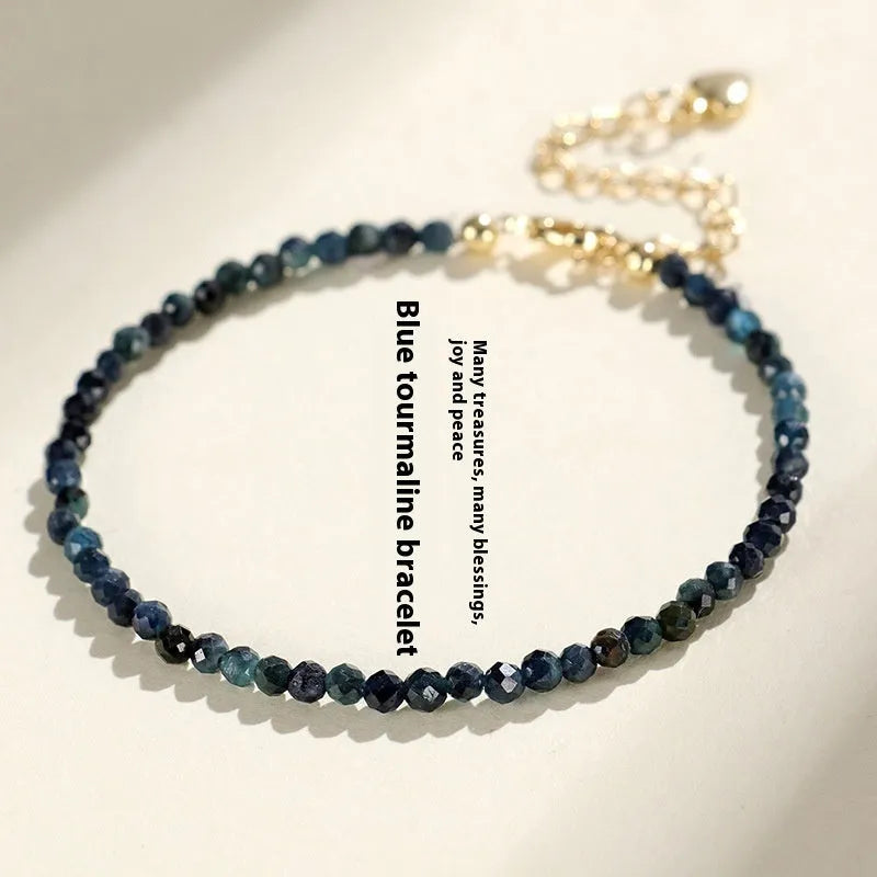 Close-up of a blue tourmaline bracelet with 3mm cut beads and spacer beads.