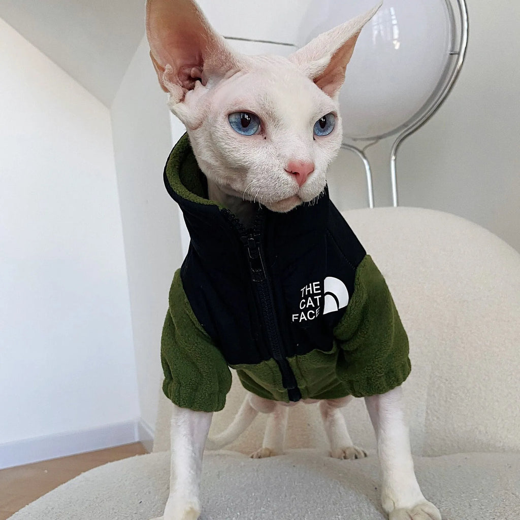 Hairless cat wearing a coral fleece jumpsuit in army green, side view on neutral background