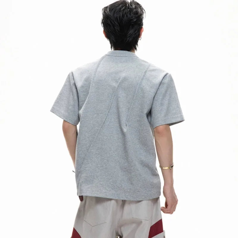Men's loose fit grey cotton T-shirt with pleated detail and asymmetric stitching on a short sleeve.