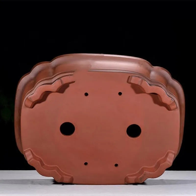 Antique-style purple clay flowerpot with Chinese decorative motifs showing tree stump, pine, cypress, pomegranate, golden marble, antique jade belt, and crabapple designs