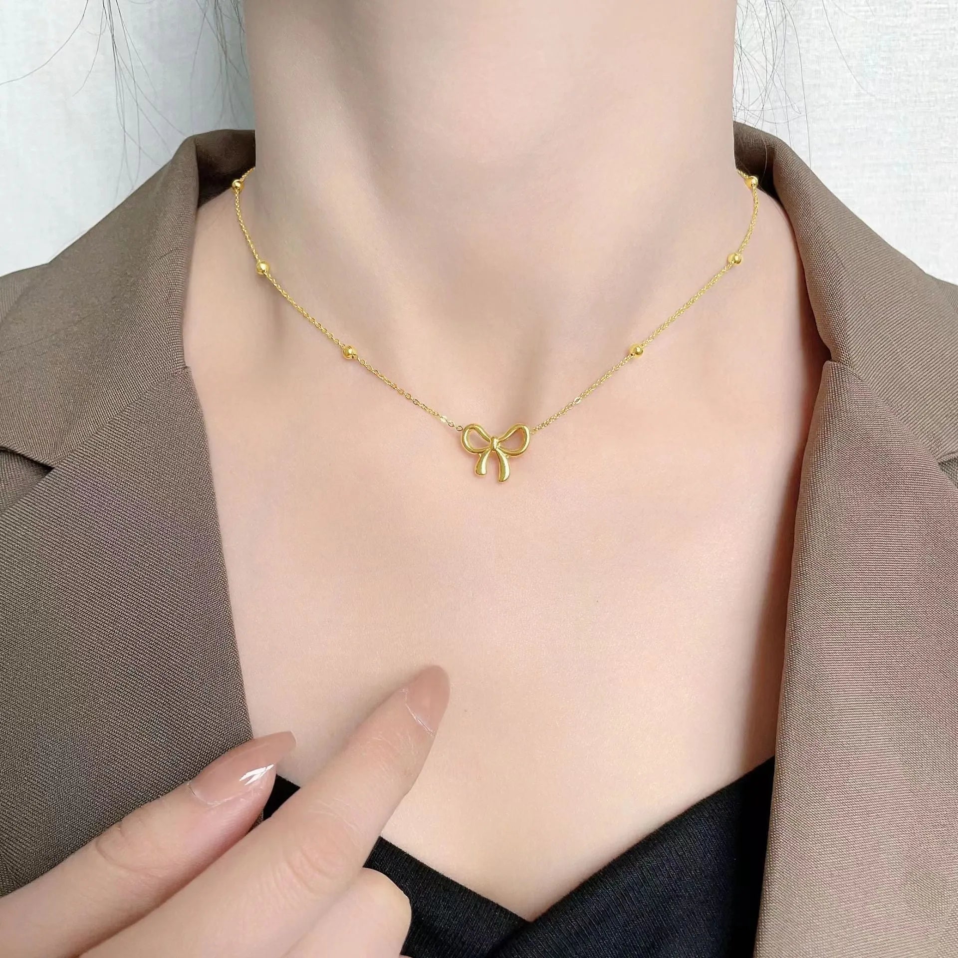 Gold electroplated bow pendant necklace on adjustable titanium steel chain