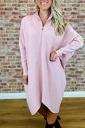 A woman wearing a solid colour loose knitted dress with raglan sleeves, shown in one of five available colours.