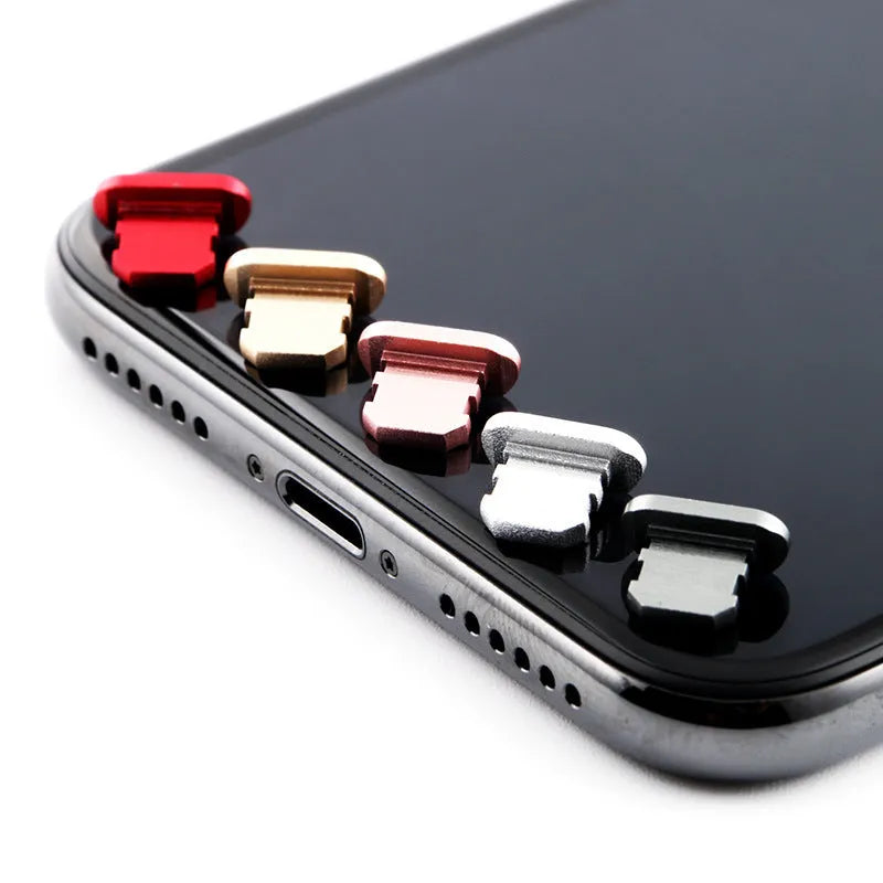 Aluminium alloy iPhone charging port dust plug in rose gold colour next to an iPhone.