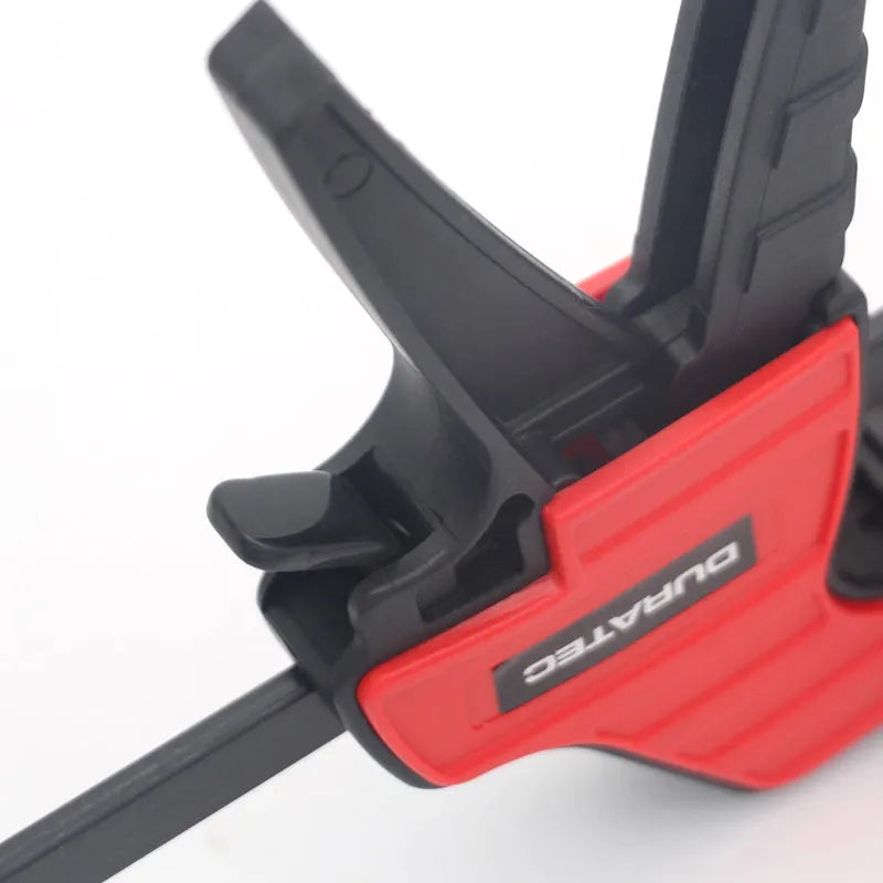 Black plastic woodworking clamp with soft rubber grip and quick regression key, available in multiple sizes