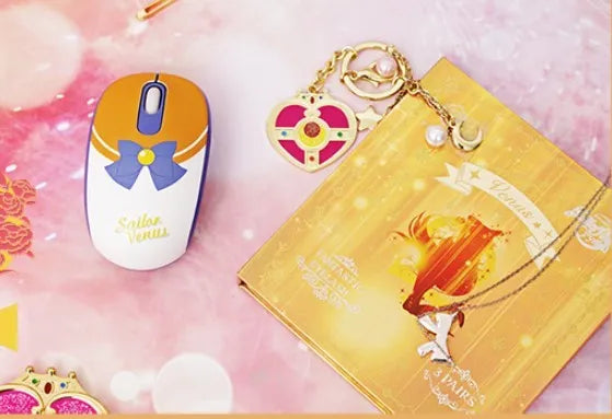 Pink Sailor Moon cartoon-themed wireless mouse with USB receiver on a desk.